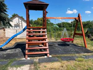 a playground with a swing set and a blue hose at Luna Vendégház in Székesfehérvár