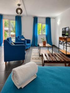 a living room with blue furniture and blue curtains at The Sanctuary MADAGASCAR in Foulpointe