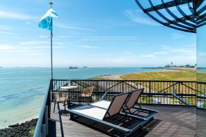a balcony with chairs and a view of the ocean at Punt al Mare in Vlissingen