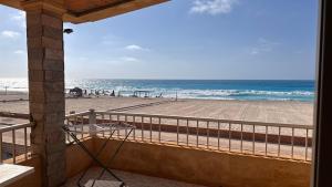 a balcony with a view of the beach at Beachfront Villa Sea View First Row in Dawwār ‘Abd Allāh