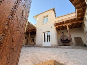 a house with a large building with a large window at Ismat Premium Guest House in Bukhara