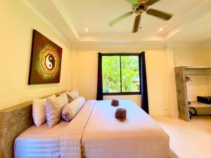a bedroom with a large bed with a ceiling fan at Viking House Villa Deluxe in Ko Tao +8 photos
