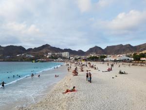 a group of people on a beach near the water at Tina Bay in Mindelo