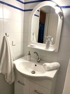 ein weißes Badezimmer mit Waschbecken und Spiegel in der Unterkunft Aethera Maisonette in Kokóni + 40 Fotos
