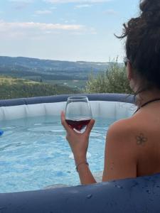 a woman holding a glass of wine in a swimming pool at La Terrazza in Collina in Cavalo
