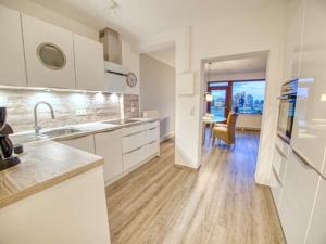 a kitchen with white cabinets and a dining room at Meer mit Blick, Dat witte Hus in Rettin