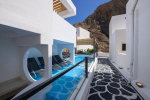 a villa with a swimming pool with mountains in the background at Angelo Boutique Hotel Santorini in Perissa