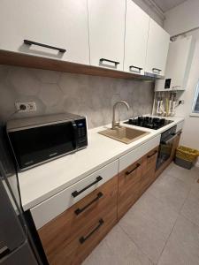 a kitchen with a sink and a microwave at Two-room apartment in Dudu +16 photos