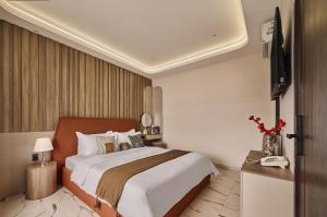 a bedroom with a bed and a flat screen tv at Luckin Hotel Lê Đức Thọ by Urban B in Ho Chi Minh City +16 photos