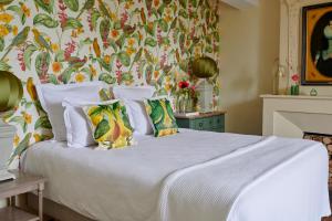 a bedroom with a white bed with a floral wallpaper at Villa Privée avec Piscine - Lavy in Saint-Pierre-de-Côle +26 photos
