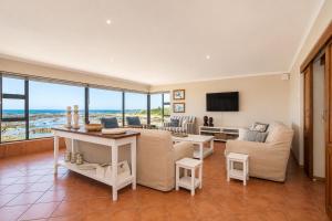 a living room with a couch and a table at High Tide Seafront at Franskraal in Franskraalstrand