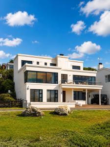 a large white house with large windows at High Tide Seafront at Franskraal in Franskraalstrand