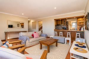 a living room with a couch and a table at High Tide Seafront at Franskraal in Franskraalstrand