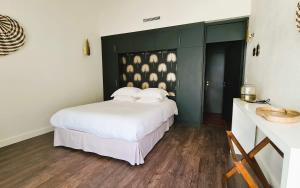 a bedroom with a white bed and a sink at L' Homillon in Saubion +8 photos