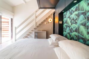 a bedroom with a large white bed and a staircase at L' Homillon in Saubion