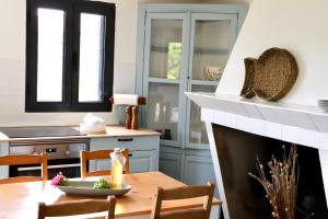 a kitchen with a table and a fireplace at Casa do Sol in Pedrógão