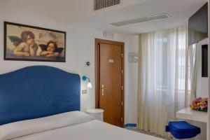 a bedroom with a bed with a blue head board at Amalfi Hotel centro storico in Amalfi