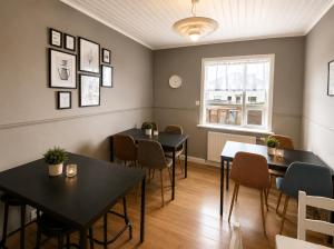 a dining room with tables and chairs and a window at Grindavik Guesthouse self check in & out in Grindavík