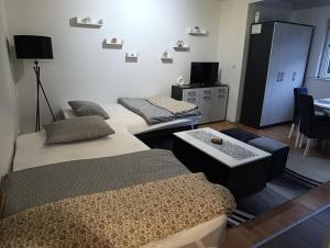 a room with two beds and a table in it at Apartman Angela in Foča