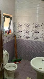 a bathroom with a toilet and a sink at الشروق in Al Ḩusānīyah