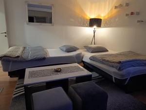 a room with two beds and a table and a lamp at Apartman Angela in Foča