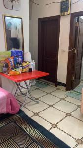 a room with a red table with food on it at الشروق in Al Ḩusānīyah