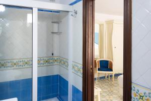 a bathroom with a shower with blue and white tiles at Amalfi Hotel centro storico in Amalfi +65 photos