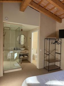 a bedroom with a glass shower and a bed at Boutique Hotel Atelier - Adults only in Sant Pere Pescador
