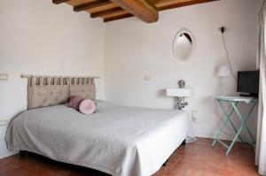 a bedroom with a bed with a pink pillow on it at Corte delle Giuggiole in Cologna Veneta