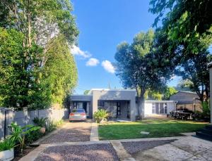 a house with a car parked in the driveway at Kaleaba House on the Riverside in Parys