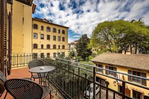 a balcony with chairs and a table and a building at Grand Hotel Panama Firenze in Florence