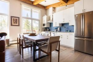 a kitchen with a table and chairs and a refrigerator at Mountainside Top Floor Condo - Treetops Lionshead in Vail