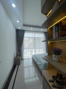 a bedroom with a bed and a large window at Van Khe Cozy Villa in Hà Ðông