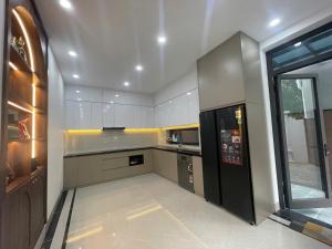 a large kitchen with a black refrigerator in it at Van Khe Cozy Villa in Hà Ðông