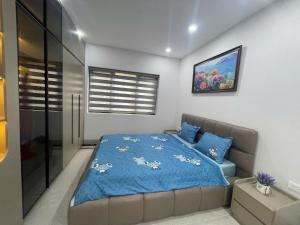 a bedroom with a bed with a blue comforter at Van Khe Cozy Villa in Hà Ðông +22 photos