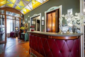 a lobby with a bar with flowers on it at Grand Hotel Panama Firenze in Florence