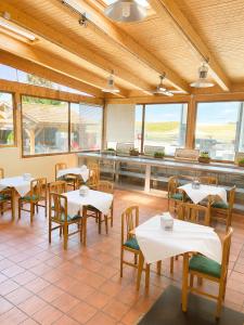 a restaurant with white tables and chairs and windows at Hostal la Abuela in Simancas