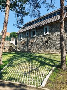 a stone building with trees in front of it at Apartmány Haberschie in Řehlovice