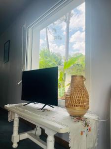 a computer monitor sitting on a table in front of a window at Forest Garden Retreat with Pool near the Beach in Seignosse