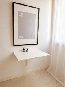 a white shelf in a room with a picture on the wall at Appartamento Donà 2 in Rovigo