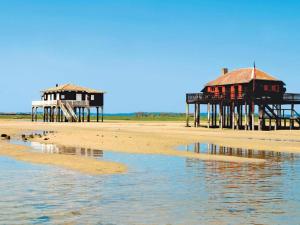 two buildings on a beach next to the water at Arcachonnaise 5 chambres, 500M de la plage et 6 vélos à disposition in Arcachon