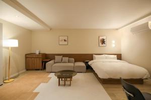 a bedroom with a large bed and a couch at Anook Hotel Suwon Ingye in Suwon +182 photos