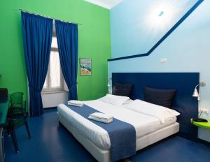a bedroom with a large bed with blue and green walls at Correra 241 Lifestyle Hotel in Naples