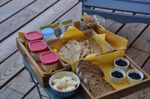 a tray of bread and other foods on a table at La Cabane 14 climatisée - Escapade sur le Bassin d'Arcachon - Terrasse & Nature in Lanton +9 photos