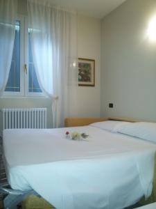 a bedroom with a white bed with flowers on it at Hotel Bruna in Lizzano in Belvedere