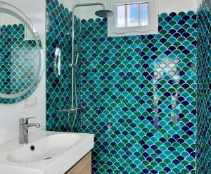 a blue tiled bathroom with a sink and a shower at Canaryislandshost I Marino in Famara +22 photos