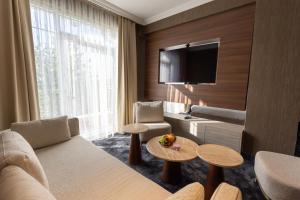a hotel room with a couch and a tv at SOI Hotel & Casino in Svilengrad