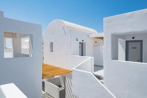 a white house with white stairs and a blue door at Angelo Boutique Hotel Santorini in Perissa