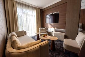 a hotel room with a couch and a bed at SOI Hotel & Casino in Svilengrad
