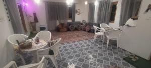 a living room with white chairs and a table at Scenic Mountain Hut Naranag in Kangan